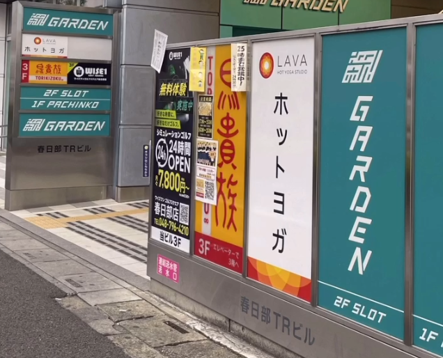 ホットヨガLAVA春日部店のビル前案内看板｜春日部TRビル1階入口付近