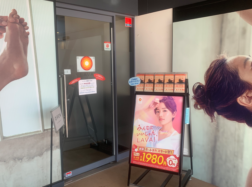 ホットヨガLAVA一宮尾西店 店舗入口付近の宣伝看板｜体験レッスン案内掲示
