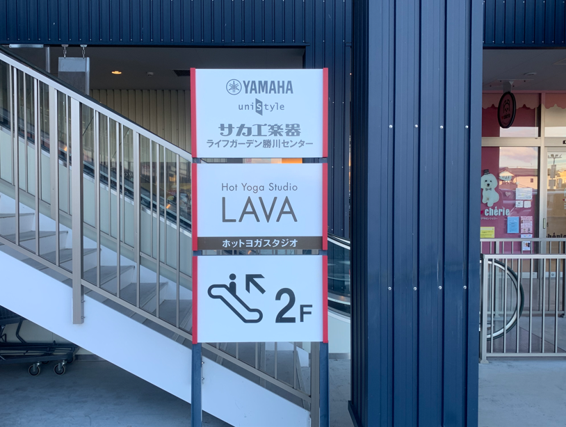 LAVA勝川店の案内看板｜ライフガーデン勝川1階の2階へ続く階段付近に設置されたスタジオ案内サイン