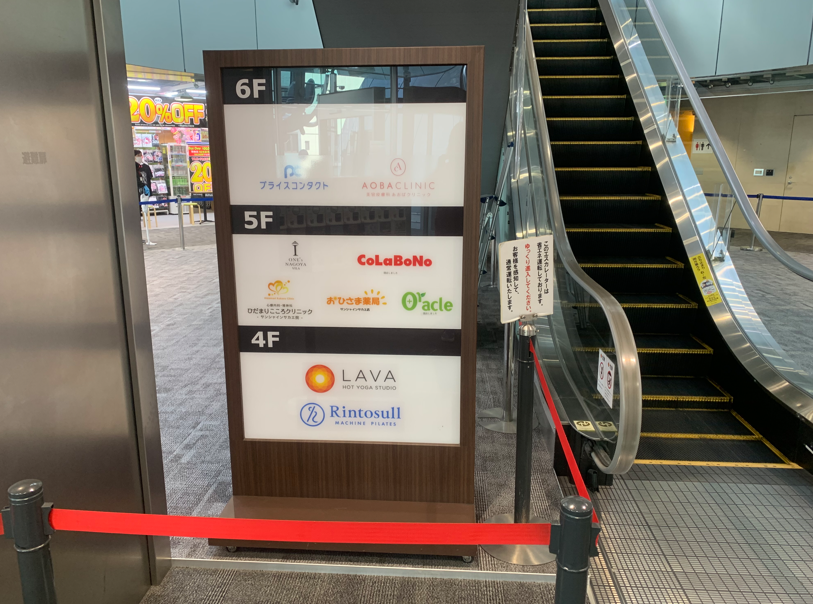ホットヨガLAVA栄店|サンシャインサカエ1階エスカレーター横に設置されたLAVA案内看板の様子
